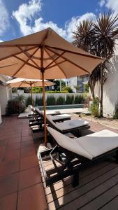 a row of lounge chairs under an umbrella on a patio at LA CURVA Casa de Playa in Villa Gesell +37 photos