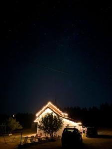 a building with lights on the roof at night at Green cottage in Blidinje