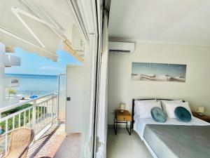 a bedroom with a bed and a balcony with the ocean at Irene Beach Front Luxury Suite in Perea