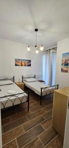 2 camas en una habitación con suelo en M&M Cozy Home, en Shëngjin