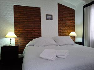 a bedroom with a white bed with two pillows on it at La Teresita Hotel Boutique in Salta