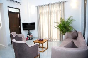 a living room with two chairs and a tv at GDS Living Pelawatta 3 Bed & 3 Bathroom Home in Battaramulla, Colombo Sri Lanka in Talangama South