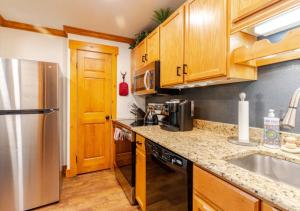 een keuken met houten kasten en een roestvrijstalen koelkast bij Red Pine Mountain Retreat steps from the Cabriolet in Park City