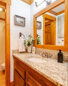 een badkamer met een wastafel en een spiegel bij Red Pine Mountain Retreat steps from the Cabriolet in Park City
