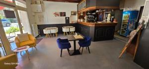 a restaurant with a bar with blue chairs and a table at Hôtel Restaurant Les Alizes Loriol Le Pouzin in Le Pouzin