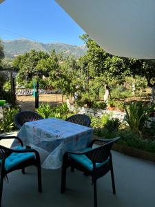 a table and chairs with a view of a garden at Cheap holiday rooms in Himare