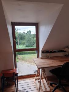 a room with a window and a table and chairs at Longère en Bretagne in Nouvoitou