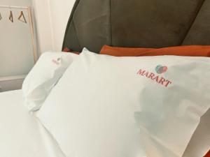 a white pillow with the name marmite on it on a bed at MarArt the living art stay in Bisceglie