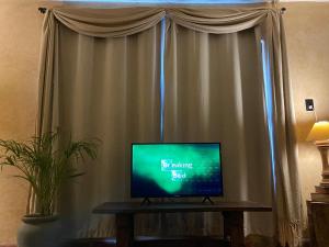 a television sitting on a table in front of a window at Casa Sílice Guesthouse in Valladolid