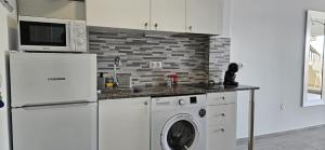 a kitchen with a refrigerator and a washing machine at Benal Beach Vibe in Benalmádena +38 photos