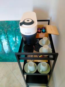 a coffee maker on a shelf with cups at Bolsena Cento20 - Rooms & Relax in Bolsena