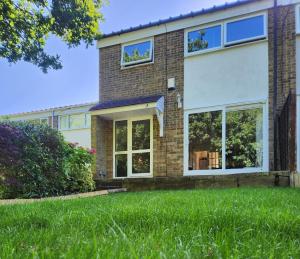 a house with large windows and a lawn at Double Room in Crawley,Gatwick,West Sussex in Ifield