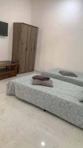 two beds sitting next to each other in a room at Bilik Umar in Gerik