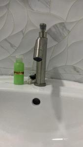 a faucet and a green bottle on a sink at Bilik Umar in Gerik +11 photos