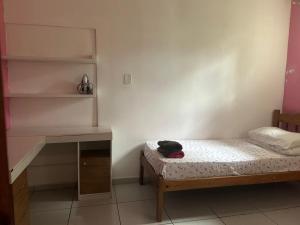 a small bedroom with a bed and a desk at Lar sossego in Itabuna