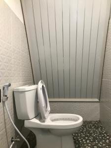 a bathroom with a white toilet in a room at Rinjani Eger Bungalow in Sembalun Lawang