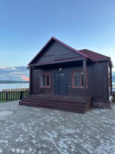 シュチュチンスクにあるLacus BOROのレンガの床にドアが付いた木造の家