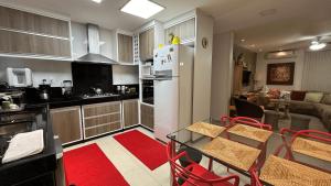 Il dispose d'une cuisine et d'un salon avec une table et un réfrigérateur. dans l'établissement Casa ampla até 19 pessoas 5min da Praia, à Rio das Ostras