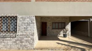 une entrée en brique d'un bâtiment avec une porte dans l'établissement Casa ampla até 19 pessoas 5min da Praia, à Rio das Ostras