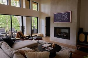 Una sala de estar con un sofá y una chimenea. en Modern luxury cabin with hot tub on river, en Ellijay