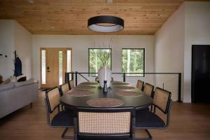Un gran comedor con mesa y sillas. en Modern luxury cabin with hot tub on river, en Ellijay