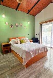 a bedroom with a bed and a green wall at Alma Vida Lofts in Fortuna