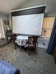 a large screen in a room with a table and chairs at Large Suite w/ Private Bath,great location in Boston