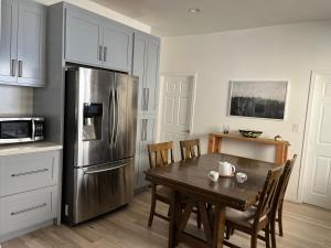 a kitchen with a table and a stainless steel refrigerator at Green House in Los Angeles