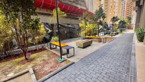 サンパウロにある820 - Rentaqui Apartamento Itaim Bibi Premiumの都市のベンチや木々のある歩道
