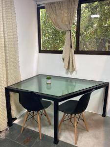 a glass table with two chairs in front of a window at Jungle AC Suite for 3-Kitchen-Walk to Playa Chiquita -Villa Toronto in Cocles +10 photos