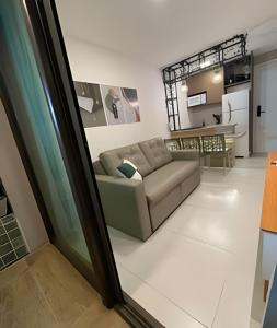 a living room with a couch and a kitchen at Flat térreo com piscina privativa in Porto De Galinhas
