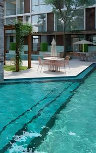 a table and chairs next to a swimming pool at Flat térreo com piscina privativa in Porto De Galinhas