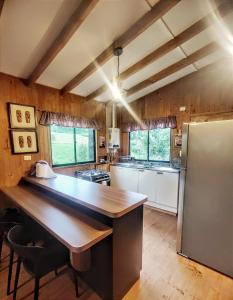 a large kitchen with a large wooden counter top at Cabaña VerdeNativo-Puerto Octay in Puerto Octay
