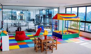 a room with a playground with a table and a play area at Flat Por do Sol in São Lourenço