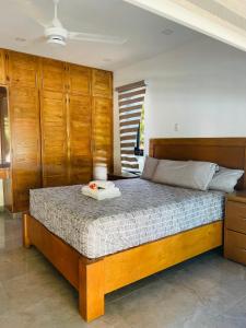 a bedroom with a large bed with wooden cabinets at Villa Plasencia in Manabao