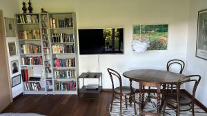 a dining room with a table and chairs and book shelves at Ferienwohnung Aubach in Frasdorf