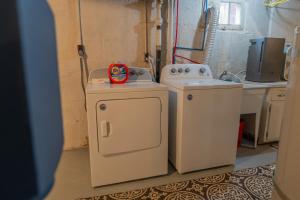a kitchen with a sink and a washing machine at Parkside Escape South Hill w Private ADU in Spokane +39 photos