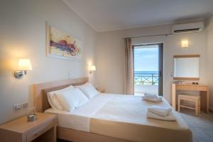 una camera con letto e vista sull'oceano di Levantino Studios & Apartments a Vasilikós