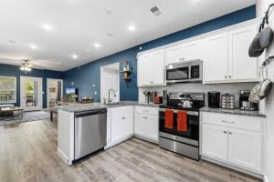 uma cozinha com armários brancos e uma parede azul em Branson Seasons Luxury Condo Pets Pool Grill Game Room Balcony em Branson