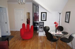 a living room with a red chair and a table at South Beach Apartments in Blackpool