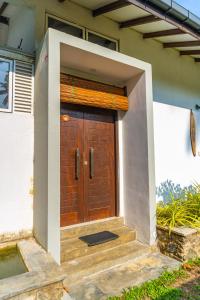 a wooden door on a house with stairs at Piyum villa in Weligama