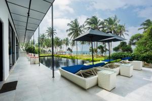 a resort with a pool with lounge chairs and an umbrella at Green Turtle Villa by TSC, Bentota in Bentota