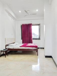 a bedroom with a bed with a red curtain at Shree Krishna Hotel in Udaipur
