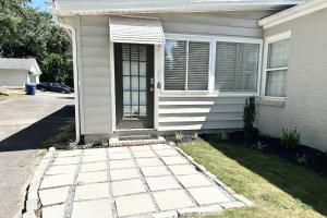 ein weißes Haus mit einer Tür und einem Rasenplatz in der Unterkunft Charming Ranch with Great Vibes in Lawrenceville + 36 Fotos