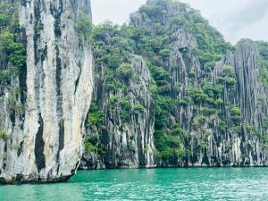 un bateau dans une masse d'eau à côté d'une montagne dans l'établissement Like hostel, à Hai Phong