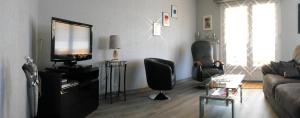 a living room with a couch and a television at maison Mia Nonna avec garage et cour in Kaltenhouse
