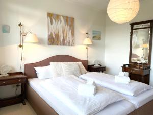 a bedroom with a large bed with two white towels at Apartmenthaus Frauenpreiss FeWo 308 in Cuxhaven +13 photos