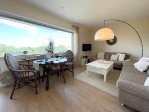 a living room with a table and a couch at Apartmenthaus Frauenpreiss FeWo 308 in Cuxhaven
