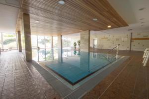 a swimming pool in a building with a large window at Apartmenthaus Frauenpreiss FeWo 308 in Cuxhaven
