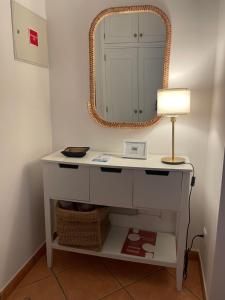 a dressing table with a lamp and a mirror at Moradia V3 na Urbanização Praia Verde in Praia Verde